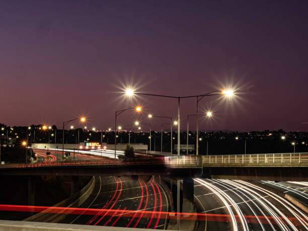 istock Multi lane free way with light trails and urban skyline 1591087060