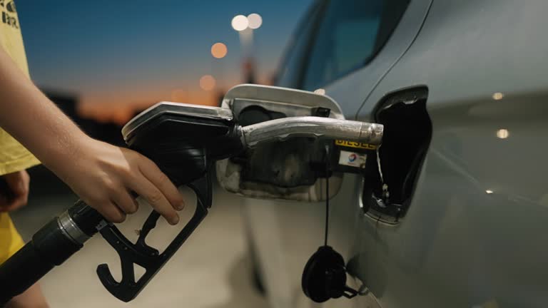 SLO MO Unknown Person Refueling Car at Gas Station Pump at Sunset