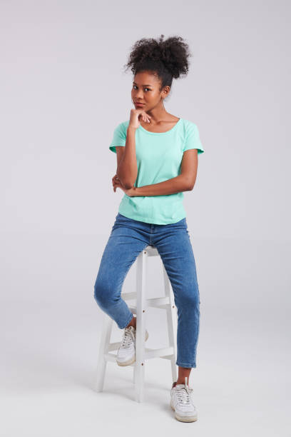 istock Casual Chic: Woman's Studio Pose in Mint Shirt and Blue Jeans 1591142049
