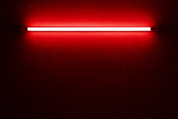 istock Red neon bulbs on black stone wall. Background texture of empty black stone wall with red neon light lamp style glow. 1591196071