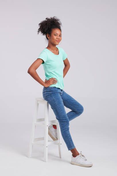 istock Seated Elegance: Woman's Mint Shirt and Blue Jeans Pose 1591208059