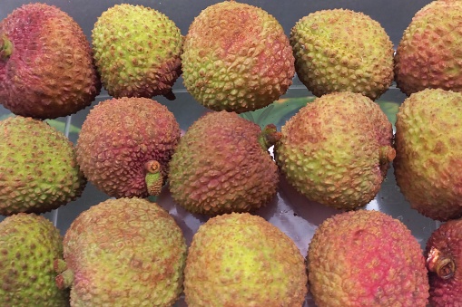 Lychee fruits with white flesh fruit, red and green skin, brown seed, and sweets flavour