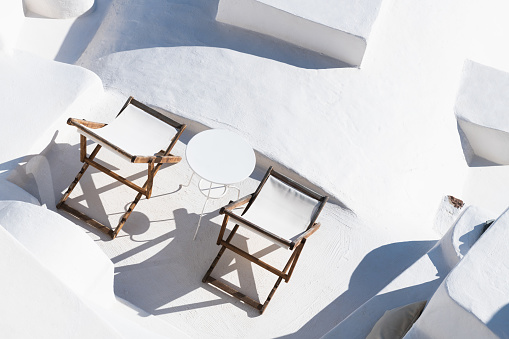 White architecture in Santorini island, Greece. Chaise lounges on the terrace with sea view. Travel and vacation concept