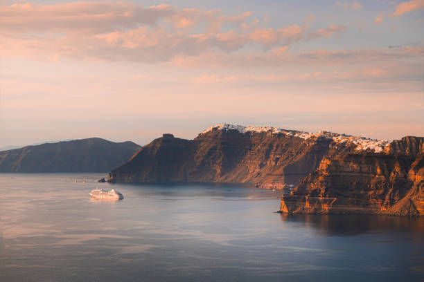 Beautiful sunset at Santorini island, Greece. Cruise ship near the coast. stock photo