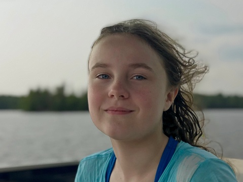 11-year-old girl with blue eyes and pigtails wearing cream-colored clothes.