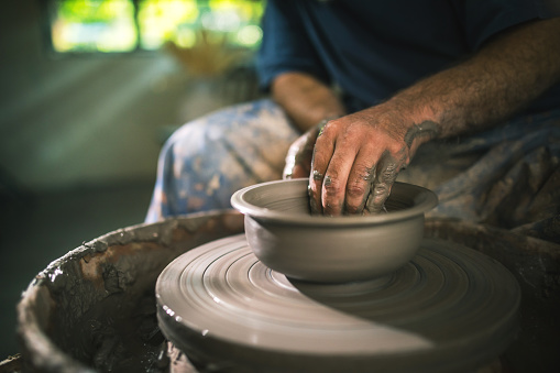 shoot of an unrecognisable man working with clay in a pottery studio