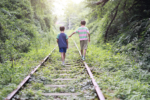 Boys walking on rail track
