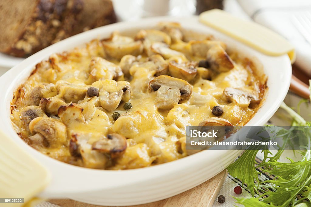 Baked mushrooms, potatoes and cheese closeup Baked mushrooms, potatoes and cheese. Vegetables closeup Edible Mushroom Stock Photo