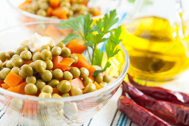 Salad with canned green peas and boiled carrots close up. Healthy and vegetarian food