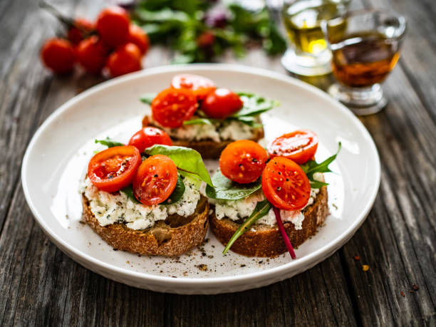 Breakfast - cottage cheese, bread and vegetables on wooden table