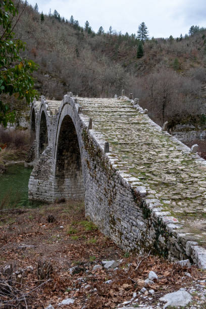 istock Greece Kalogeriko or Plakidas stone bridge with three arch, Epirus. View from rocky path. Vertical 1591324698
