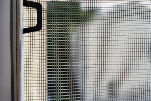 Close up on mosquito wire screen installation on window to protect from insects.