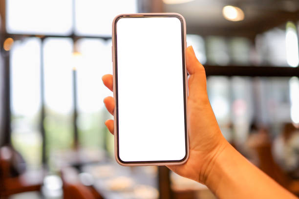 istock Women's hands holding cell telephone blank copy space screen. smartphone with blank white screen isolated on white background . smart phone with technology concept 1591348959
