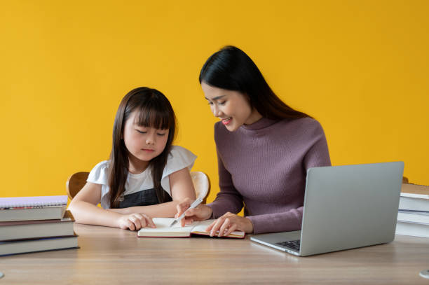 istock A caring Asian female private tutor is teaching math to a cute little girl at a study table. 1591354978