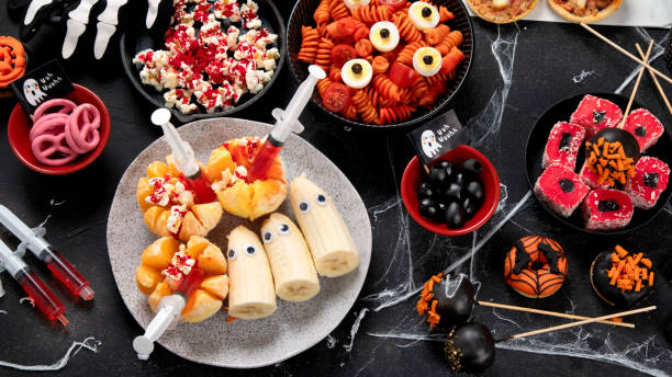istock Halloween sweets for Halloween party on black background. top view 1591369419