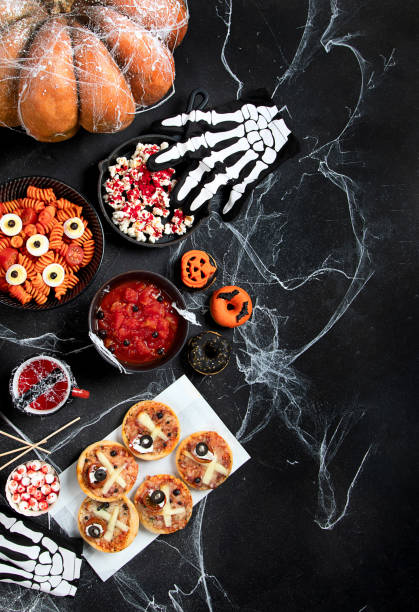 istock Halloween sweets for Halloween party on black background. top view 1591370525