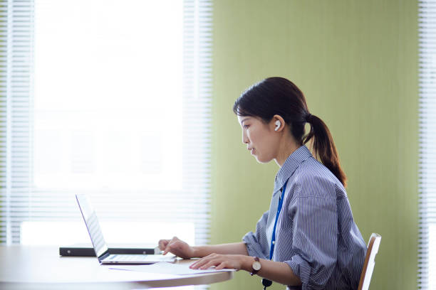 istock Japanese woman working using a laptop in the office 1591399836