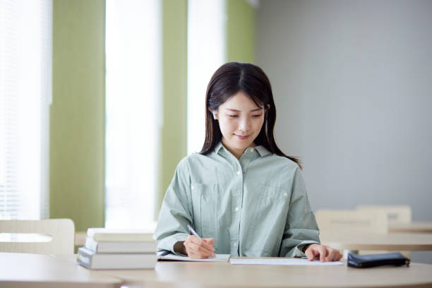 istock Japanese woman studying in the library 1591399863