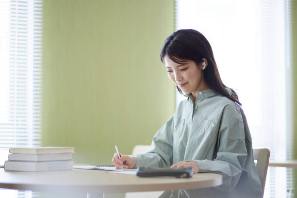 istock Japanese woman studying in the library 1591399876