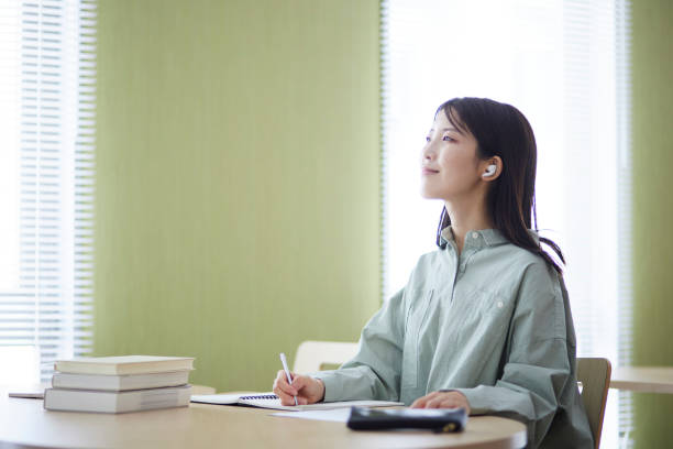 istock Japanese woman studying in the library 1591399877