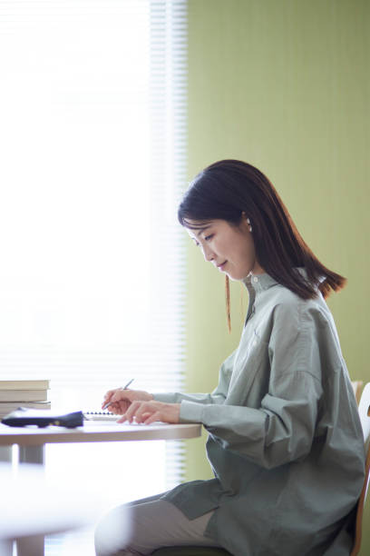 istock Japanese woman studying in the library 1591399879