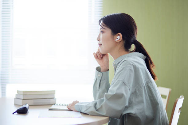 istock Japanese woman studying in the library 1591400320