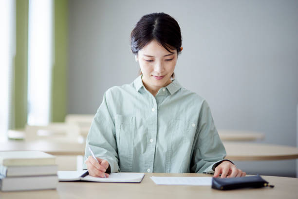 istock Japanese woman studying in the library 1591400392