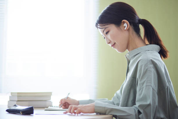istock Japanese woman studying in the library 1591400398