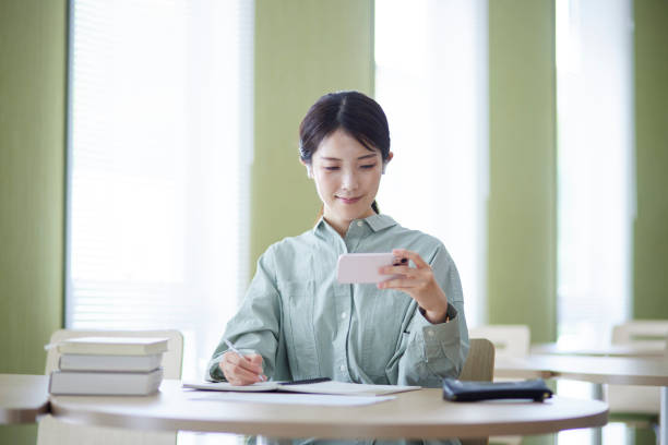 istock College students studying using smartphones in the library 1591400407