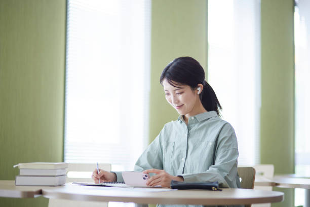 istock College students studying using smartphones in the library 1591400411