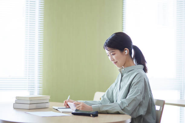 College students studying using smartphones in the library