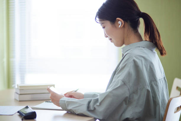 istock College students studying using smartphones in the library 1591400417