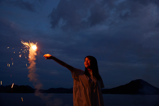 A Japanese woman in her thirties who enjoys handheld fireworks in the summer sea