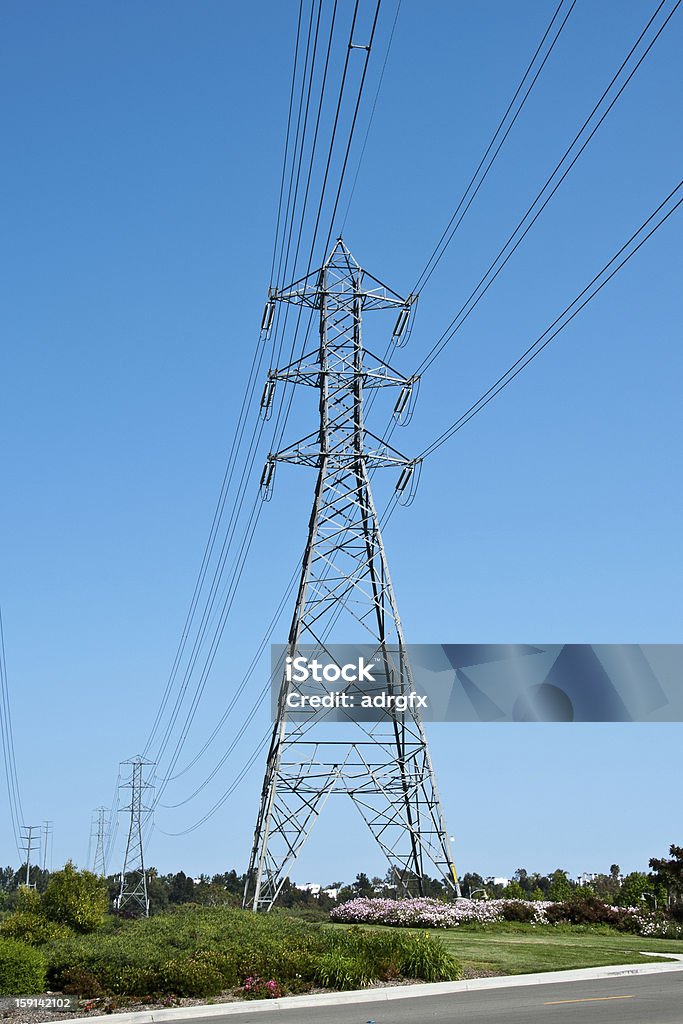 high voltage power lines в яркой поле - Стоковые фото Башня роялти-фри