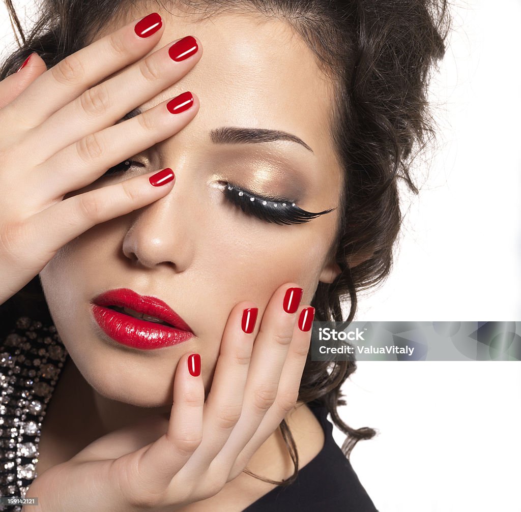 Model with red nails, lips and creative eye makeup Beautiful fashion model with red nails, lips and creative eye makeup  - isolated on white background Adult Stock Photo