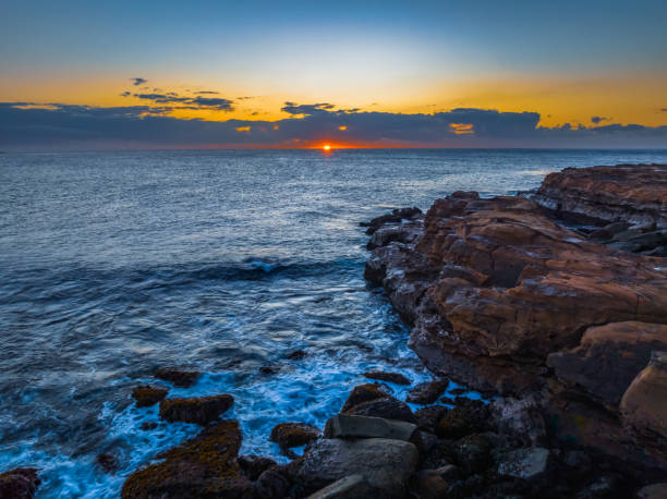 istock Sunrise over the ocean with low clouds on the horizon 1591423151