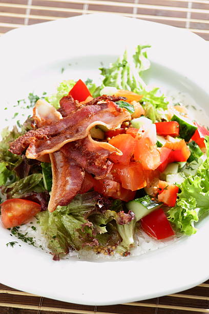 Salad with fried bacon on plate. Selective focus, shallow DOF.