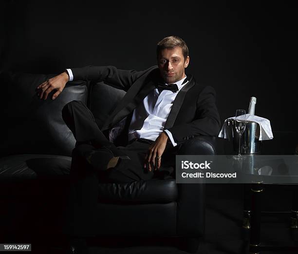 Sexy Man In Tuxedo Waiting With Champagne On A Couch Stock Photo - Download Image Now