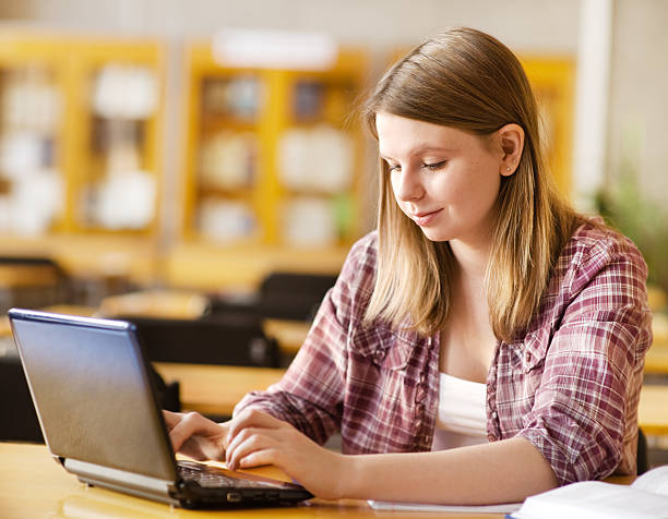 istock student with laptop and books working in a library 159142708