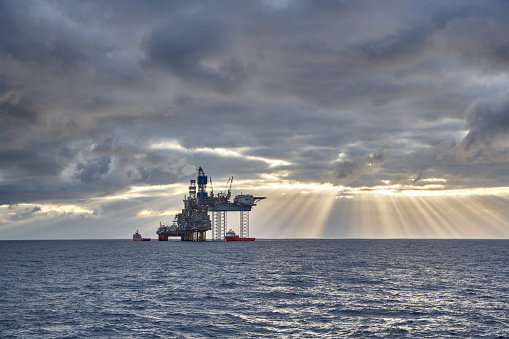 Beautiful view of a jack up drilling rig in the sea. Oil and gas offshore platform view in the sunset at sea.