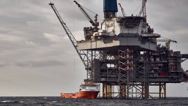 istock Supply vessel doing cargo operations with jack up drilling rig, offshore platform in the sea. 1591456088