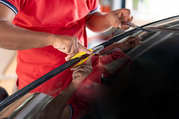 istock Cutting car film on front windscreen glass surface 1591458702