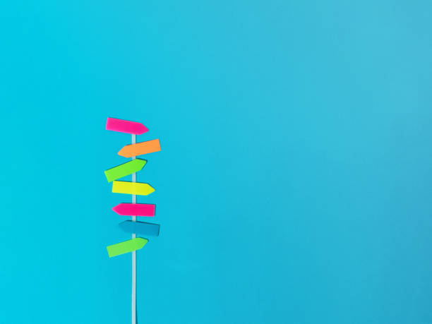 istock Funny direction multicolor signpost on blue background. Summer concept. Flat lay. 1591459887