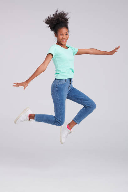 istock Fashion Flight: Woman's Mint Shirt and Blue Jeans Leap 1591463447