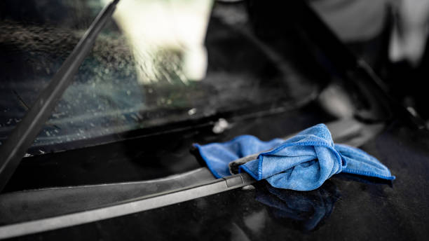istock Blue cloth wipe or cleaning rag on car front windscreen 1591468322