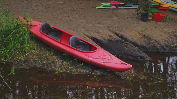 istock Red Two Seat Kayak Parked on River Bank 1591487980