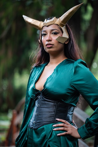 A young female cosplayer is dressed in a costume depicting Loki, a popular Marvel Comics character