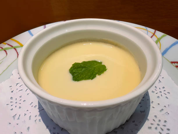 istock Steamed sweet vanilla egg custard or pudding or Custard cream, creme brulee in the white cup, decorated with mint leaf, traditional dessert menu 1591508090