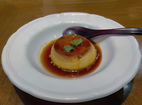 Traditional original style vanilla caramel custard pudding with burnt caramel sauce serving in a white plate, Japanese restaurant, sweet dessert menu