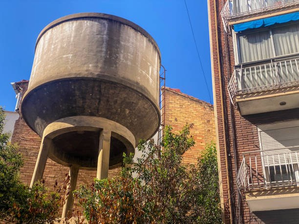 Yellow water tanks on a building against a blue sky in Brazil. Shows urban infrastructure, aging, or water supply.
